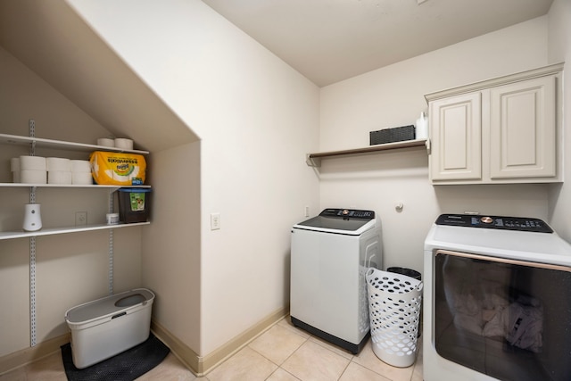 washroom with separate washer and dryer, baseboards, light tile patterned flooring, and cabinet space