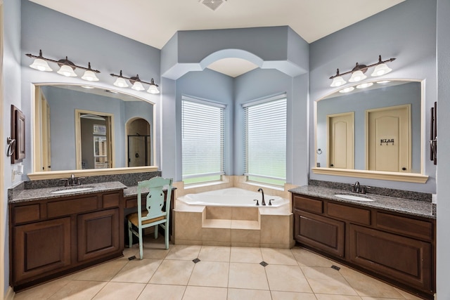 bathroom featuring a sink, tile patterned flooring, a bath, and two vanities
