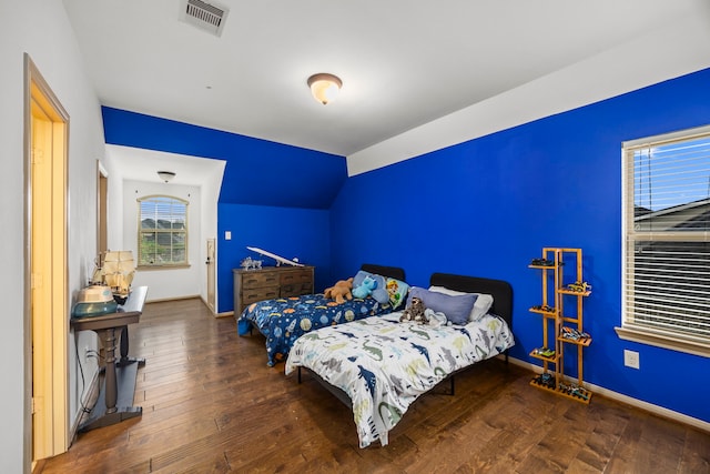 bedroom with visible vents, baseboards, lofted ceiling, and hardwood / wood-style flooring