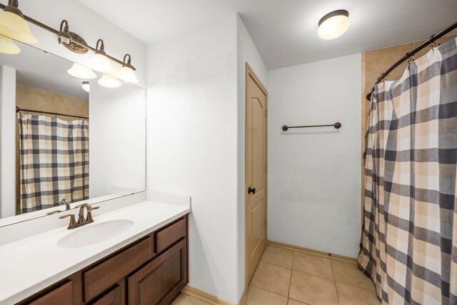 bathroom with a shower with curtain, baseboards, tile patterned flooring, and vanity