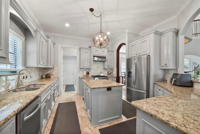 27603 Siandra Creek Ln, Spring, TX 77386 - kitchen with stainless steel appliances, a sink, arched walkways, light stone countertops, and ornamental molding
