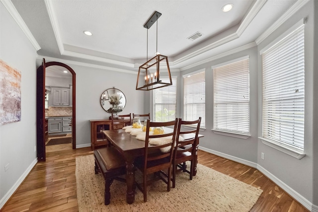 27603 Siandra Creek Ln, Spring, TX 77386 - dining room featuring a raised ceiling, arched walkways, wood finished floors, ornamental molding, and recessed lighting