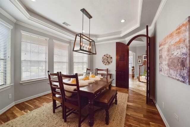 27603 Siandra Creek Ln, Spring, TX 77386 - dining area featuring a raised ceiling, arched walkways, crown molding, wood finished floors, and a chandelier