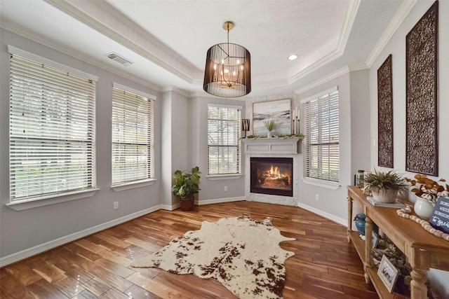 27603 Siandra Creek Ln, Spring, TX 77386 - living area featuring a raised ceiling, crown molding, a glass covered fireplace, wood-type flooring, and baseboards