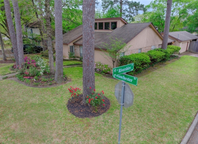 view of front of home featuring a front yard and a shingled roof