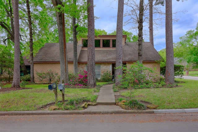 mid-century home with a front yard and roof with shingles