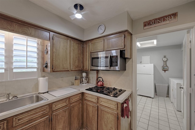 900 Manchester Dr, Conroe, TX 77304 - kitchen featuring freestanding refrigerator, stainless steel microwave, gas stovetop, ceiling fan, and light countertops