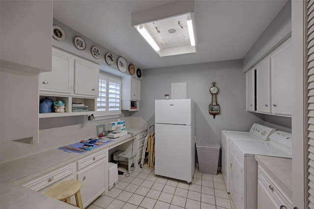 900 Manchester Dr, Conroe, TX 77304 - laundry area featuring washer and clothes dryer, light tile patterned floors, a desk, and cabinet space