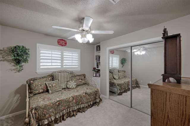 900 Manchester Dr, Conroe, TX 77304 - bedroom featuring light colored carpet, a closet, a textured ceiling, ceiling fan, and baseboards