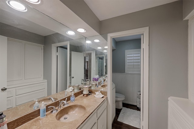 900 Manchester Dr, Conroe, TX 77304 - full bathroom with vanity, toilet, a wainscoted wall, and wood finished floors