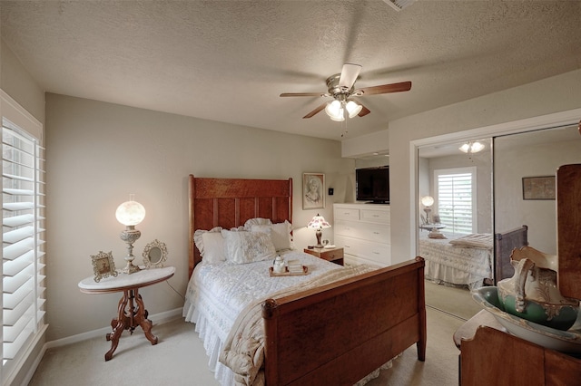 900 Manchester Dr, Conroe, TX 77304 - bedroom featuring light carpet, ceiling fan, baseboards, a closet, and a textured ceiling