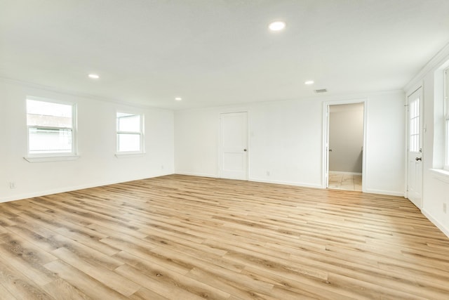 spare room featuring light wood finished floors, recessed lighting, and baseboards