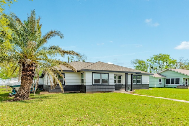 view of front facade featuring a front yard and roof with shingles