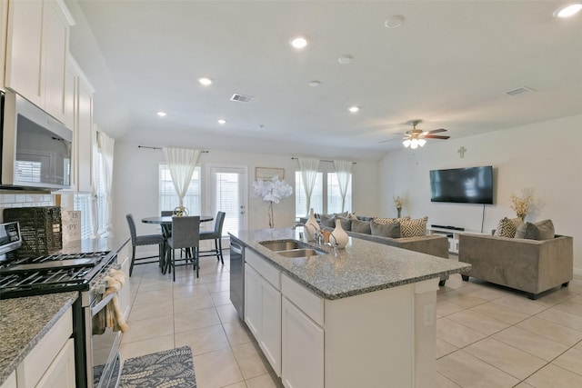 kitchen with light tile patterned flooring, a sink, open floor plan, stainless steel appliances, and visible vents