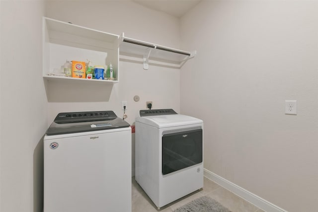 washroom featuring baseboards, separate washer and dryer, laundry area, and light tile patterned floors