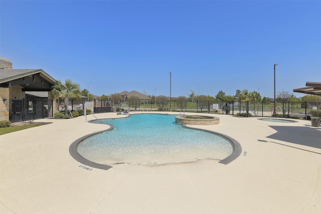 pool featuring a hot tub, fence, and a patio