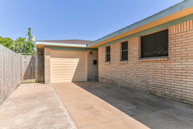 view of patio with fence, a garage, and concrete driveway