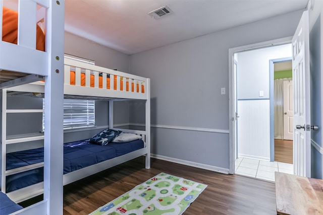 bedroom featuring wood finished floors, baseboards, and visible vents
