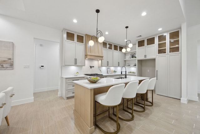 1252 Rd 6604, Dayton, TX 77535 - kitchen with a sink, decorative backsplash, baseboards, an island with sink, and light countertops