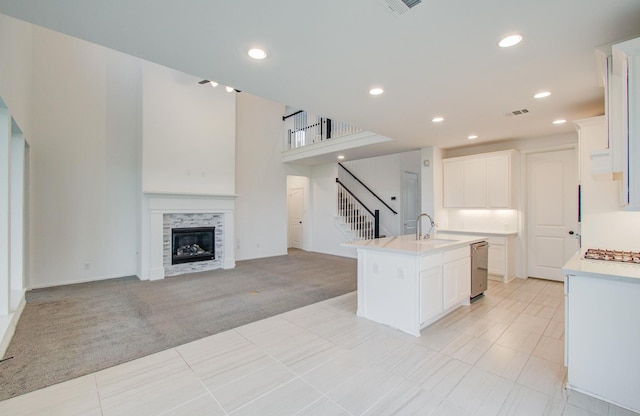 693 Cape Capri Dr, Katy, TX 77493 - kitchen with light countertops, a kitchen island with sink, light carpet, a sink, and open floor plan