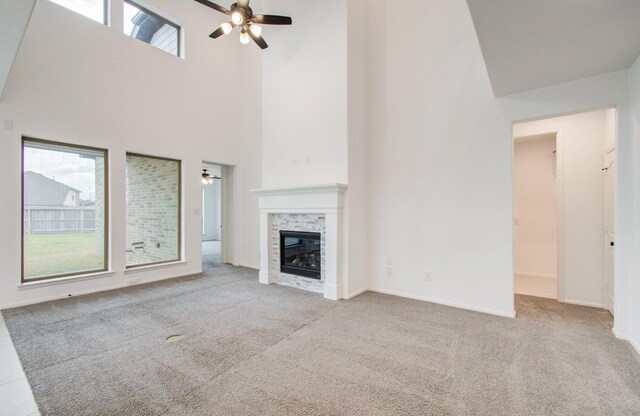 693 Cape Capri Dr, Katy, TX 77493 - unfurnished living room featuring a towering ceiling, carpet floors, a fireplace, baseboards, and ceiling fan