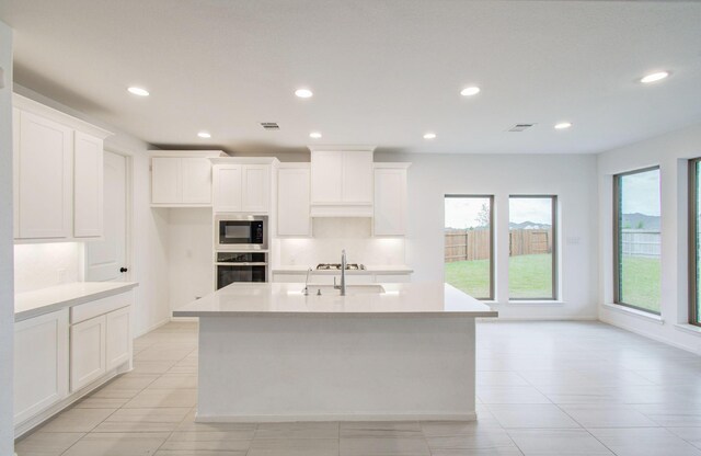 693 Cape Capri Dr, Katy, TX 77493 - kitchen featuring built in microwave, visible vents, a sink, and stainless steel oven