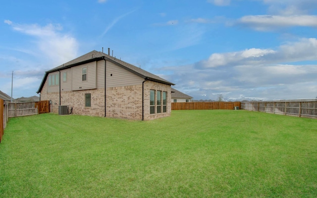 693 Cape Capri Dr, Katy, TX 77493 - rear view of house featuring a fenced backyard, brick siding, central AC, and a yard