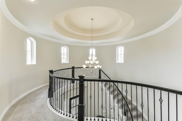 17429 Orchid Falls Ln, Conroe, TX 77302 - hallway featuring an upstairs landing, a chandelier, a raised ceiling, baseboards, and plenty of natural light