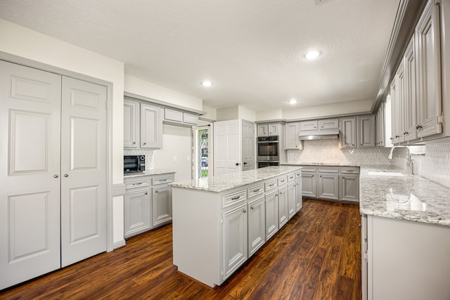 11814 Drexelbrook Dr, Houston, TX 77077 - kitchen featuring gray cabinets, dark wood-type flooring, tasteful backsplash, a kitchen island, and light stone countertops