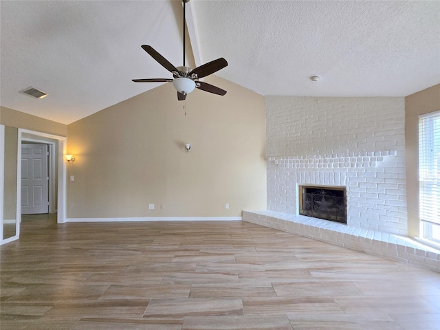 unfurnished living room featuring a textured ceiling, ceiling fan, visible vents, and vaulted ceiling