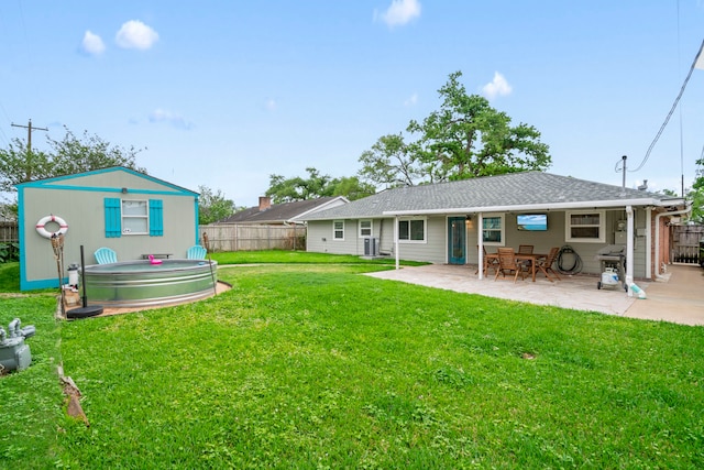 rear view of house with a lawn, a patio area, and fence