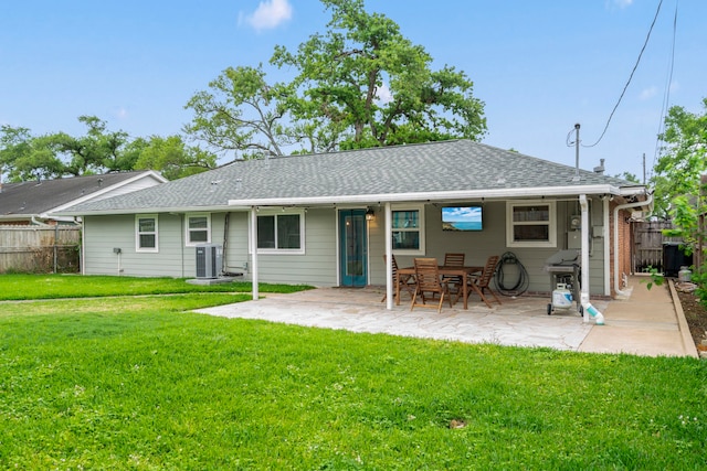 rear view of property with a patio area, fence, a yard, and roof with shingles