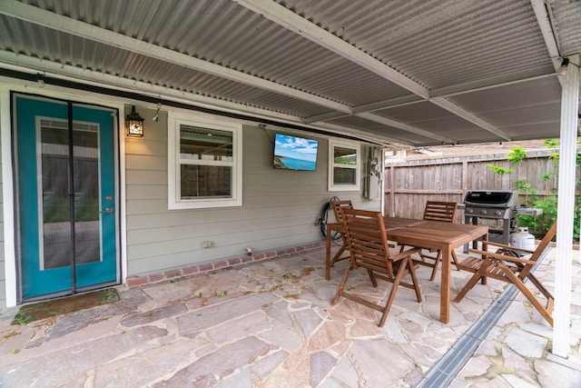 view of patio with fence, outdoor dining space, and a grill
