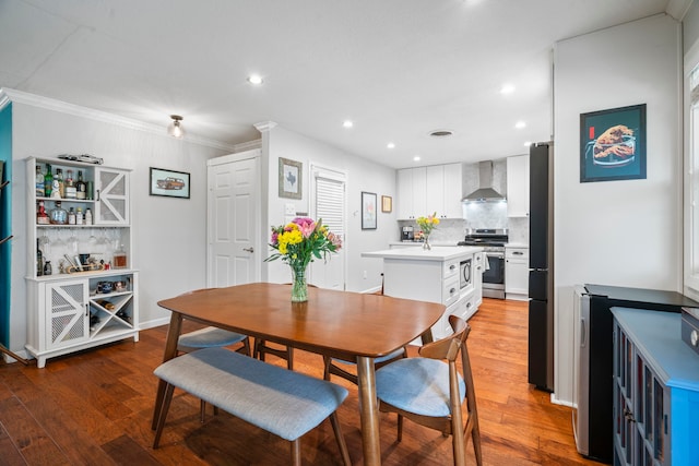 dining space with light wood-style floors, baseboards, ornamental molding, and recessed lighting