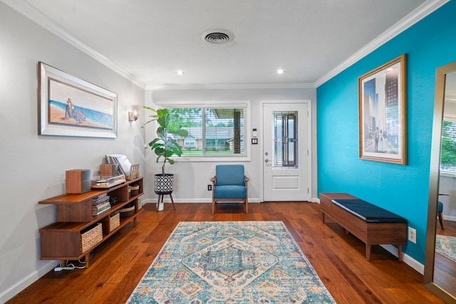 foyer entrance featuring visible vents, crown molding, plenty of natural light, and wood finished floors