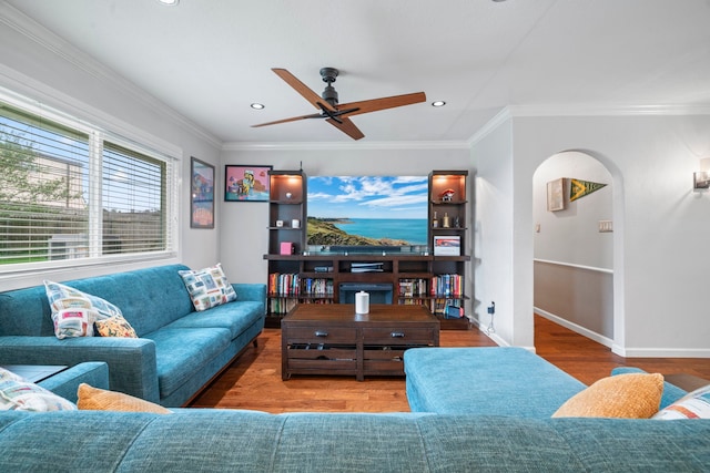 living area featuring a ceiling fan, arched walkways, wood finished floors, baseboards, and recessed lighting