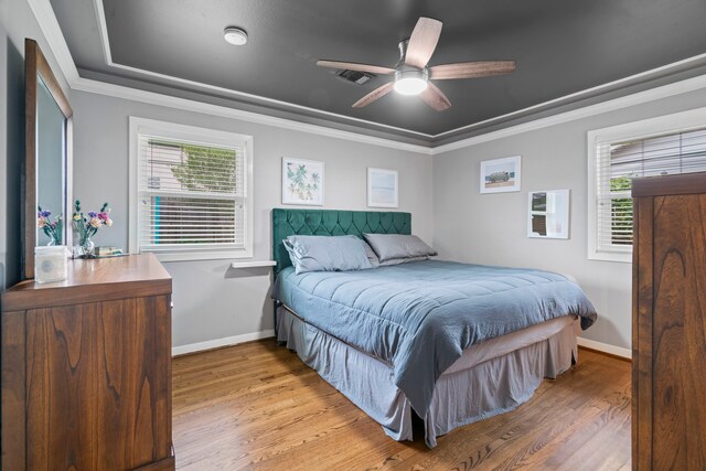 bedroom with baseboards, ornamental molding, ceiling fan, and light wood finished floors