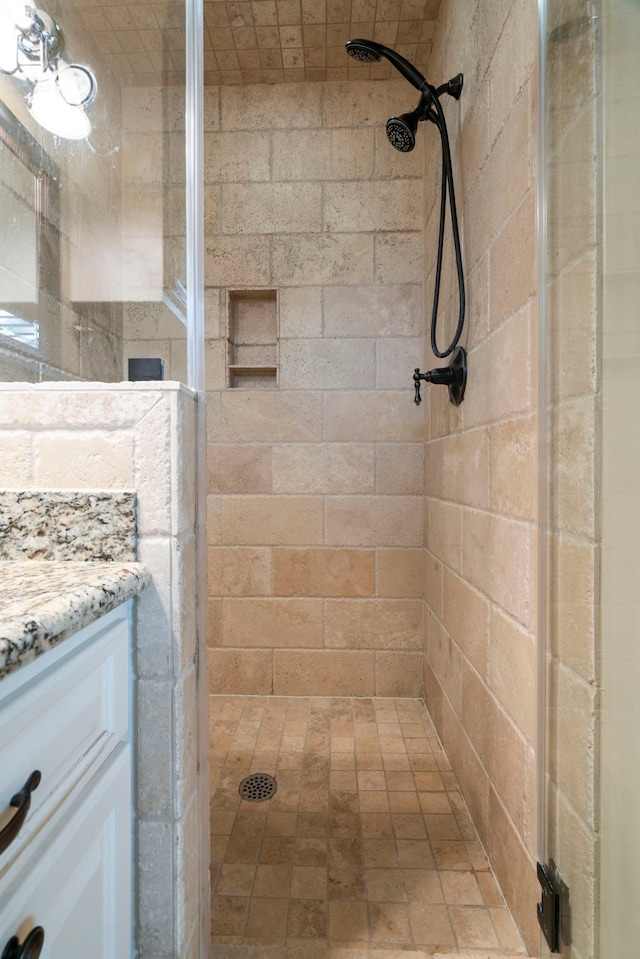 bathroom featuring a shower stall and vanity
