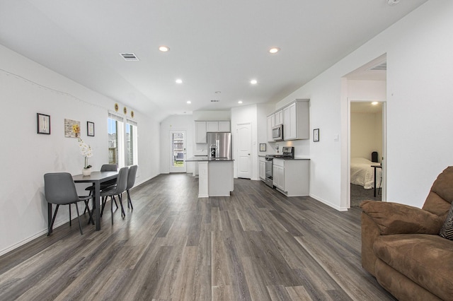 4984 Pismo Ray Dr, Katy, TX 77493 - kitchen featuring open floor plan, dark countertops, an island with sink, visible vents, and appliances with stainless steel finishes