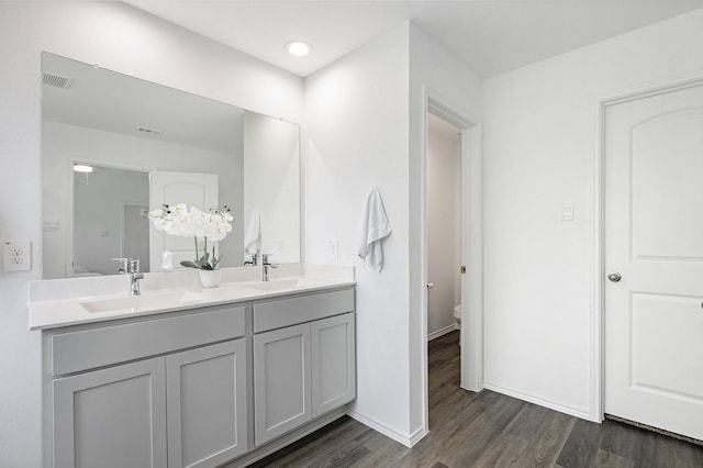 4984 Pismo Ray Dr, Katy, TX 77493 - bathroom with visible vents, double vanity, toilet, wood finished floors, and a sink
