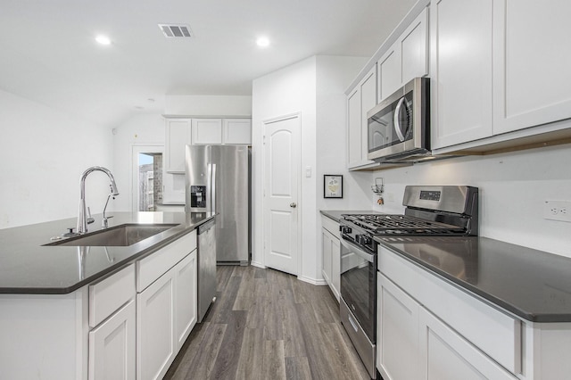 4984 Pismo Ray Dr, Katy, TX 77493 - kitchen with dark wood-style flooring, visible vents, dark countertops, appliances with stainless steel finishes, and a sink