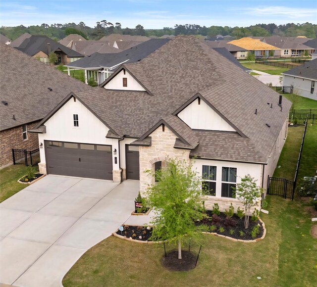 14886 Shavers Dr, Willis, TX 77318 - view of front of home with a shingled roof, stone siding, driveway, a residential view, and an attached garage