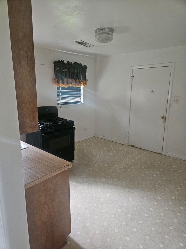 112 N Parrish St, Angleton, TX 77515 - kitchen with black gas range and baseboards