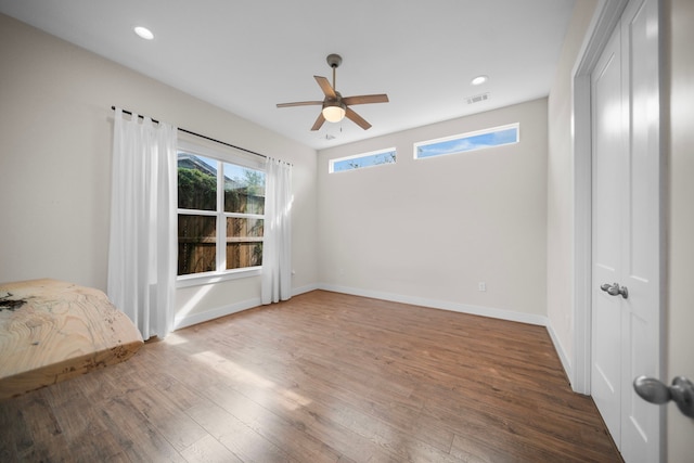 unfurnished bedroom featuring wood finished floors, recessed lighting, baseboards, and a ceiling fan