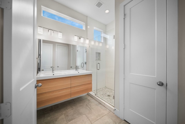 bathroom featuring a shower stall and double vanity