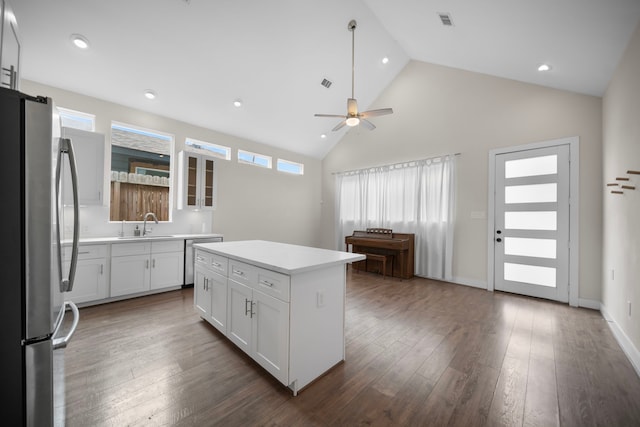 kitchen with stainless steel appliances, a ceiling fan, a center island, a sink, and light countertops