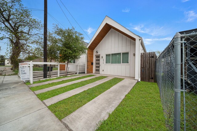 view of front of house featuring board and batten siding and fence