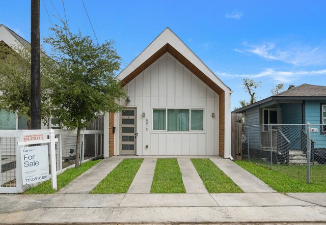 view of front facade with board and batten siding and fence