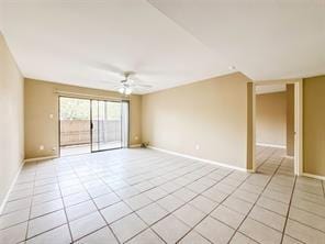 empty room featuring baseboards, ceiling fan, and light tile patterned floors