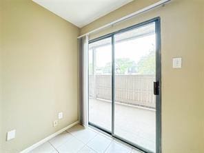unfurnished room featuring light tile patterned floors and baseboards